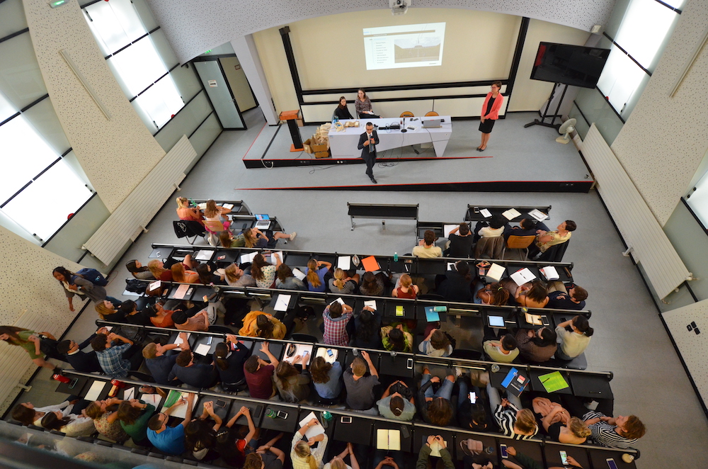 Vue du dessus d'élèves écoutant une présentation orale