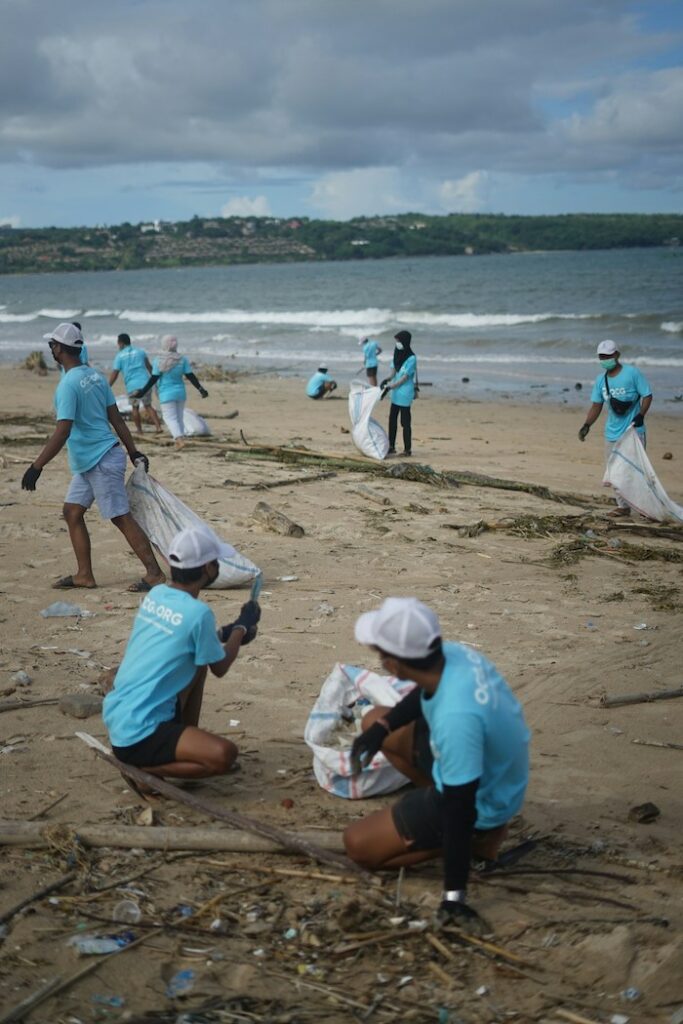 personnes en tshirt bleu qui ramasse des déchets sur la plage