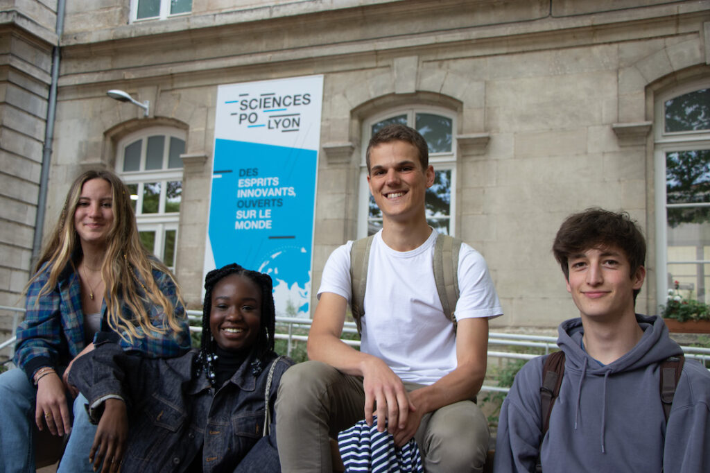 4 elèves souriant avec une affiche sciences po en fond