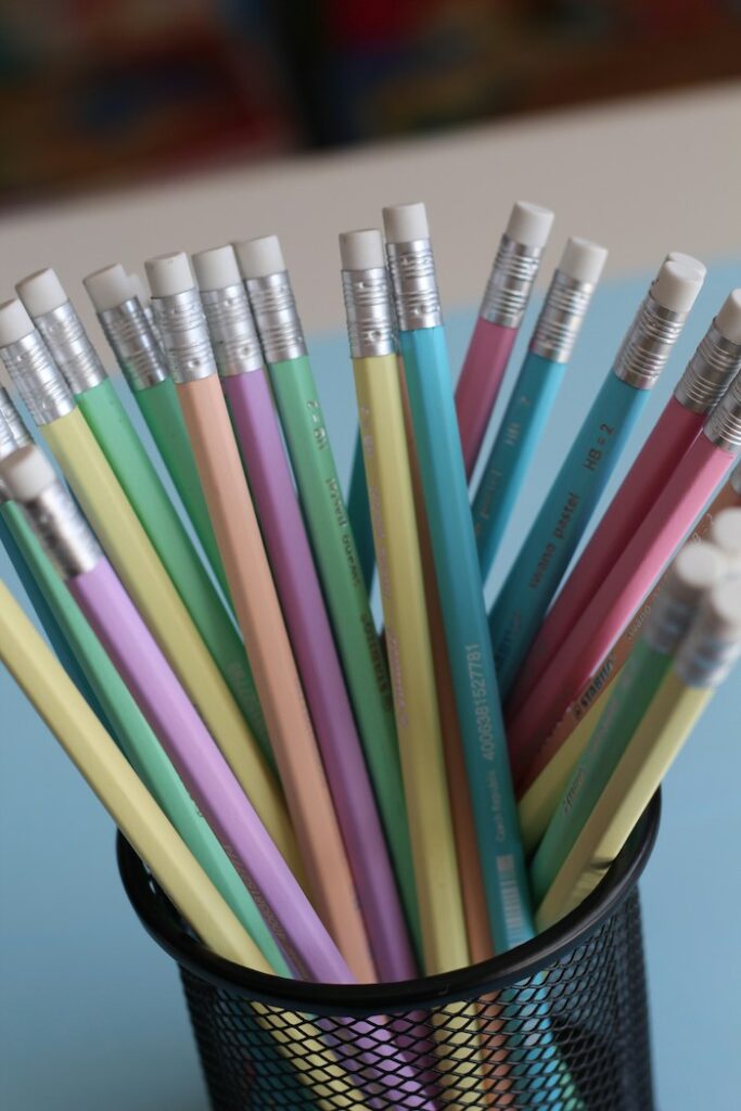 crayon de papier de couleurs pastels et une petite gomme dans un pot noir