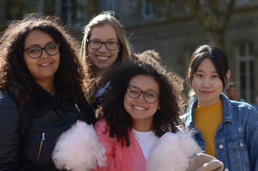4 filles souriantes, dont deux avec des barbe à papa à la main