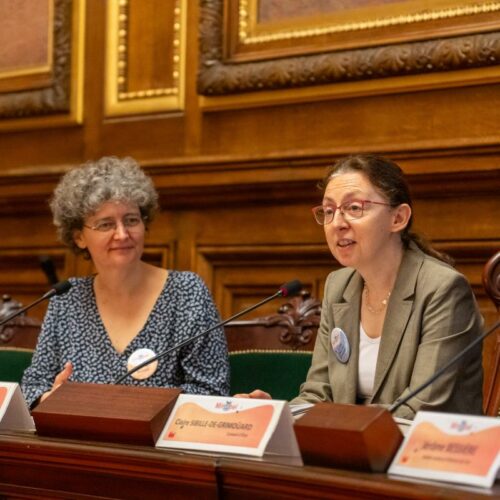 Deux femmes assises dont une qui parle au micro