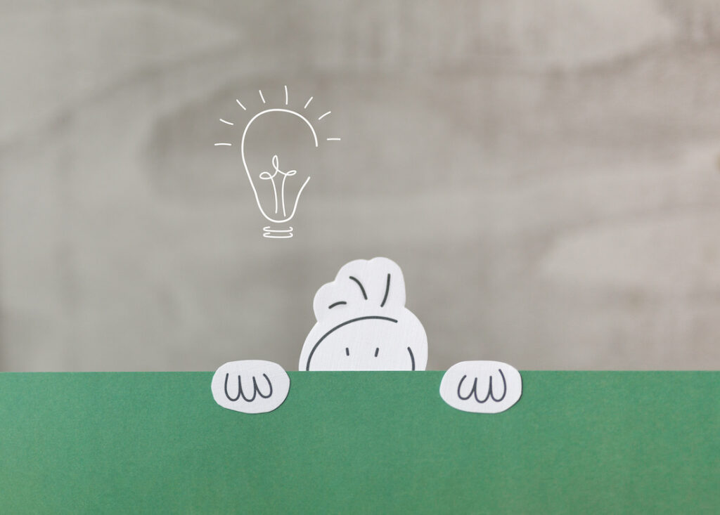 Illustration d'un bonhomme qui se cache à moitié derrière un mur vert, avec une lampe à gauche