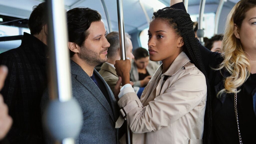 Un homme et une femme qui s'accroche à une même bar de métro. l'homme frole la main de la femme