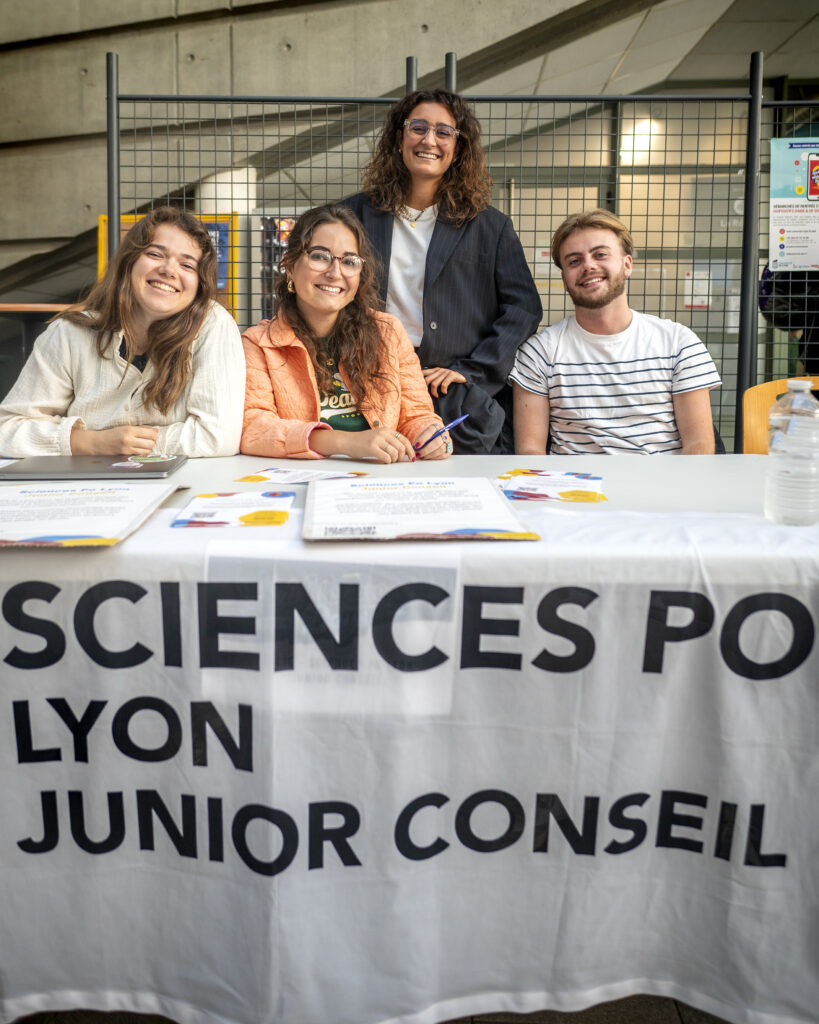 4 personnes derrière une table de stand Sciences Po Lyon Junior conseil