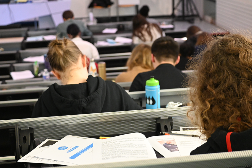 Amphitheâtre avec des élèves qui travaillent de dos