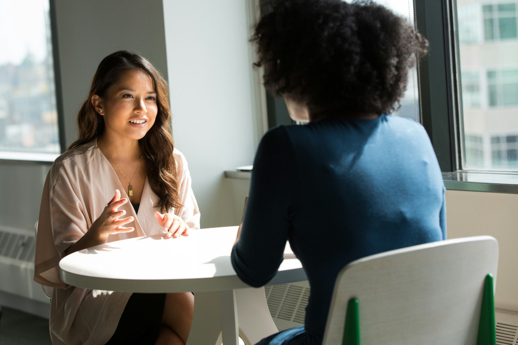 Deux femmes se parlant face à face sur une table ronde
