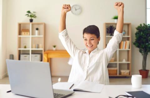 Femme heureuse derrière son ordinateur